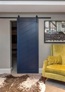 a living room with a yellow chair and black sliding barn door in the middle of it