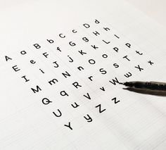 a pen sitting on top of a piece of paper with letters and numbers written in it