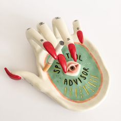 a ceramic hand that has red nails on it