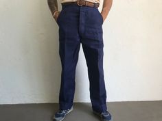 "French blue work trousers - Macober Made in France 1970s High waist pants in indigo blue sanforized cotton . Straight cut with crease. 5 button closure. Bakelite buttons. All originals. 2 side pockets, 1 buttoned back pocket. 5 belt loops. In perfet condition. New item. Deadstock With original cardbord label . Never washed. Label size: 42/12 The model usually wears a size M (40/42) and measurs 175cm - 68,8,\" Measurements (flat): Waist: 42cm - 16,5\" Hips: 54cm - 21,2\" Crotch: 33cm - 12,9\" fr Vintage Jeans Trousers For Work, Retro Work Pants With Pockets, Vintage Bottoms With Flat Front And Pockets, Vintage Flat Front Bottoms With Pockets, Retro Work Pants For Workwear, Retro Full Length Work Pants, Vintage Style Work Pants With Welt Pockets, Retro Blue Jeans For Work, Vintage Blue Bottoms For Work