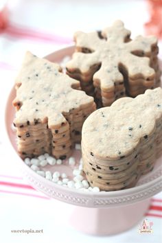 some cookies are on a plate with white and black sprinkles around them