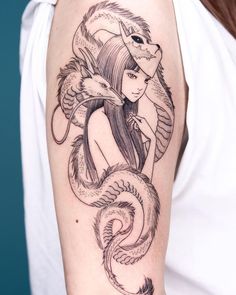 a woman with a dragon tattoo on her arm, holding a snake and wearing a hat