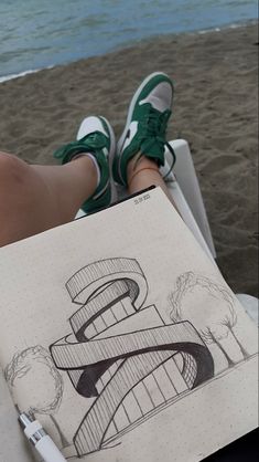 a person sitting on a beach chair holding a notebook with a drawing of a number 8