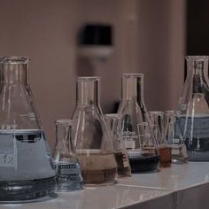 many different colored liquids in glass bottles on a counter