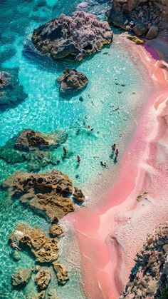 people are swimming in the blue and pink water