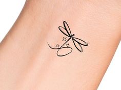 a woman's arm with a dragonfly tattoo on it