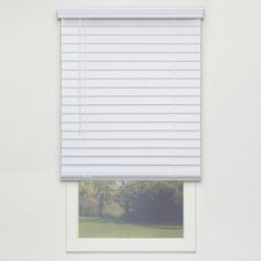 a window with white blinds on it and trees in the background