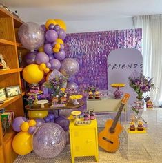 a room filled with lots of purple and yellow balloons