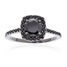 a black diamond ring with white diamonds on the band and an oval cut stone in the center