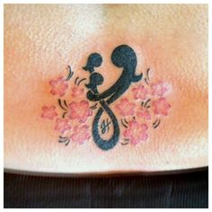 a woman's stomach with flowers and a tattoo design on the side of her belly