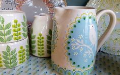 a table topped with lots of colorful cups and plates