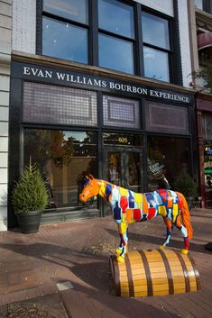 a brightly colored horse statue in front of a building