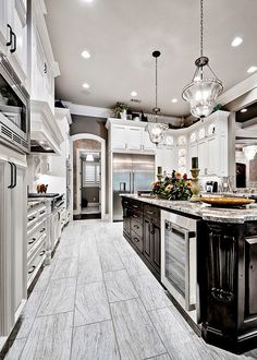 a large kitchen with white cabinets and marble counter tops