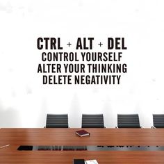 a conference table with a phone on it in front of a wall that says ctrl + alt + del control yourself, alter your thinking delete negativeity