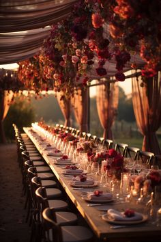 a long table is set with wine glasses and place settings for an outdoor dinner party