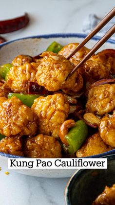 a bowl filled with chicken and peppers next to chopsticks