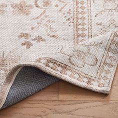 an area rug is laying on the floor with it's corner partially covered by a piece of fabric