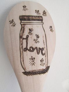 a wooden spoon with an image of a jar that says joy on it and flowers