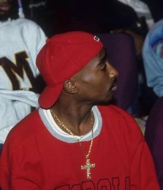 a man in a red shirt and hat sitting next to another man