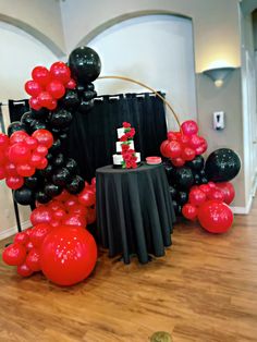 a table with black and red balloons on it