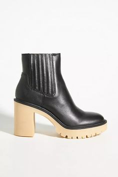 a pair of black ankle boots with wooden heeling on the bottom and soles