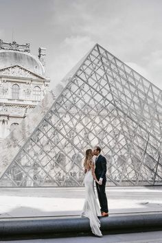 a bride and groom standing in front of the pyramid