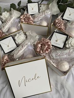 wedding favors in boxes with name tags on them and flowers next to the box that says, nicole