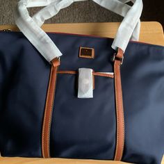 Dooney & Bourke Canvas Bag Satchel Navel Canvas With Tan Rather Accents Red Material Trim Against Gold Zipper Inside And Out Front Outside Snap Close Pocket Perfect For Your Cell Phone Inside Material Blue And White Stripe Small Matching Makeup Bag/ Change Purse Attaches Inside Nwt Blue Bags With Leather Trim And Double Handle, Blue Leather Trim Shopping Bag, Blue Bags With Leather Trim For Shopping, Blue Leather Trim Bags For Shopping, Blue Bags With Luggage Sleeve, Dooney & Bourke Bag, Disney Dooney, Brown Satchel, Tan Handbags