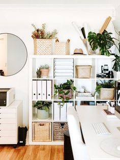 a white desk topped with lots of plants