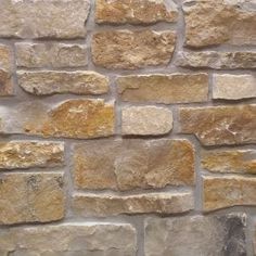 a brick wall made out of various types of stones and cements, with yellow highlights on the edges