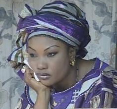 a woman in a purple dress talking on a cell phone