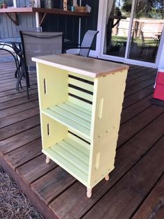 a yellow cart sitting on top of a wooden deck