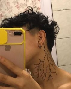 a man with tattoos on his neck taking a selfie in front of the mirror