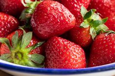 a bowl filled with lots of ripe strawberries