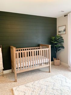 a baby's crib in the corner of a room with green painted walls