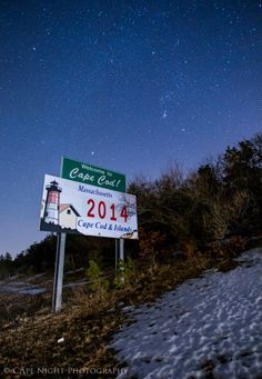 a sign that is on the side of a hill under a sky full of stars