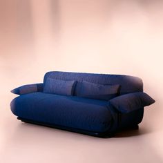 a blue couch sitting on top of a white floor