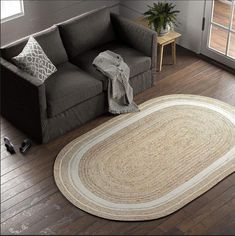 a living room with a gray couch and white rug