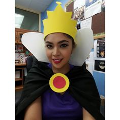 a woman with a crown on her head and cape around her neck wearing a costume