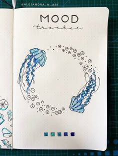 an open notebook with drawings on it and the words mood written in blue ink next to a drawing of jellyfish