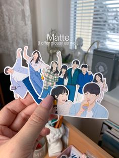 someone holding up some stickers with the characters from tv series, matte and other globsy as well