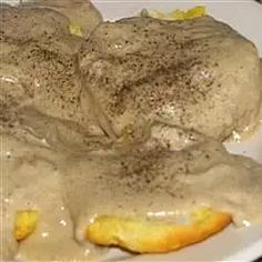 a white plate topped with meat covered in gravy