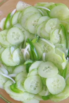 sliced cucumbers and onions in a bowl on a wooden cutting board, ready to be cooked