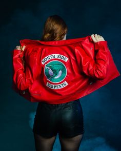 a woman in black shorts and a red leather jacket with the words south side serpents on it