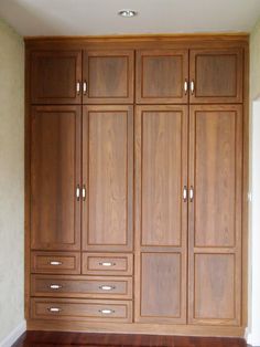 an empty room with wooden cabinets and hard wood flooring