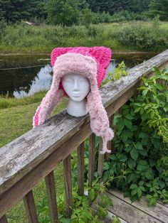 a pink hat sitting on top of a wooden fence