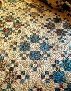 an old quilt is laying on the floor