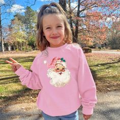 This cozy crewneck is the perfect gift for a girl or woman. Featuring the cute pink santa with leopard print hat, this shirt is stylish and cute winter wear. 𝐇𝐎𝐖 𝐓𝐎 𝐎𝐑𝐃𝐄𝐑 1. Select the size & color when applicable 2. Add the personalization (name, design etc) when required 3. Add to Cart & submit your order. 4. If ordered over $35, we have FREE shipping for you! 𝐀𝐋𝐖𝐀𝐘𝐒 𝐇𝐀𝐍𝐃𝐌𝐀𝐃𝐄 * Each item is handmade and made to order here in Florida! * We carry several different brands and use different brands for different listings, including Rabbit Skins®, Gildan®, Gerber Onesie®, Bella Canvas® and Comfort Colors®. G A R M E N T ∙ F E A T U R E S : * Unisex Fit * Commercial grade heat press S H I P P I N G * All items get sent via USPS first class mail * Priority 2-3 day shippin Trendy Winter Tops With Cartoon Print, Winter Cartoon Print Relaxed Fit Tops, Casual Winter Tops With Cartoon Print, Oversized Pink Top With Cartoon Print, Pink Letter Print Top For Winter, Winter Pink Top With Letter Print, Pink Tops With Letter Print For Winter, Trendy Winter T-shirt With Cartoon Print, Christmas Long Sleeve Tops With Cartoon Print