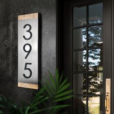 a house number sign mounted to the side of a door