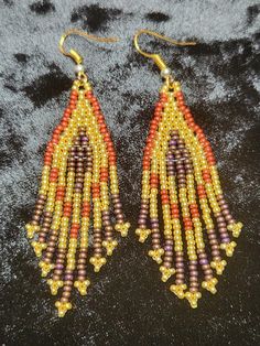 Gold, red, and brown glass seed bead earrings. Beautiful for any occasion. Bohemian Burgundy Beaded Jewelry, Red Gold Beaded Drop Earrings, Elegant Brown Beaded Earrings With Gold Beads, Traditional Gold Beaded Earrings With Tiny Beads, Elegant Brown And Gold Beaded Earrings, Brown Dangle Jewelry With Colorful Beads, Brown Tiny Beads Earrings For Gift, Dangle Jewelry With Colorful Beads, Gold Beaded Earrings With Dangling Beads For Festive Occasions